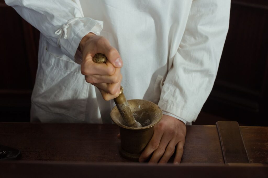Pharmacist grinding ingredients using a mortar and pestle. Traditional pharmacy preparation.
